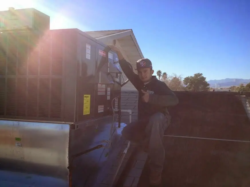 HVAC technician performing AC Tune-Up on a rooftop unit in San Clemente